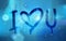 I love you words with heart drawn on a window over blurred background and water rain drops, vector realistic illustration,