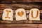 I love you written on toasted slices of bread, on wooden planks background