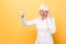 I`m winner! Portrait of a cheerful senior woman gesturing victory isolated over yellow background. Thumbs up