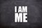 I am me white text and quotes with blackboard background.