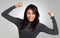 I nailed it. a beautiful young woman looking cheerful while standing against a grey background.