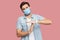 I need more time. Portrait of worry young man with surgical medical mask in blue shirt standing with timeout gesture and begging