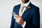 I need to take a selfie of this moment. Cropped studio shot of a stylish young groom holding a cellphone while standing