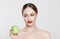 I am sick of this diet! Displeased young girl looking with disgust disliking apple isolated white background, fresh fruit diet