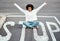 I stop at nothing. Portrait of a happy young woman sitting on a stop sign at an intersection.