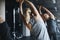 I always stretch my arms before I lift. Rearview shot of women working out in the gym.