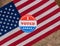 I Voted Today paper sticker on US Flag and rural wooden table