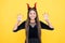 I will eat you. child in imp horns on yellow background. kid wear devil horns show claws. childhood autumn holiday