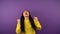 I won A tense Asian woman in a yellow sweater looks forward to the result and wins. woman on purple isolated background