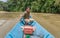 Iban man steering his longboat up the river on Borneo