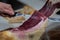 Iberian ham cut into small slices with a knife.