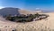 Ica oasis desert. Lagoon in the middle of dunes surrounded by trees and some houses.