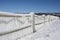 Ice blanketed rope fence facing the harbor on Seneca Lake after w