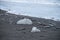 Ice blocks and pebbles on black sand beach