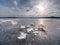 Ice breaking. Floe on frozen lake with sunset sky