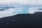 Ice breaking from icebergs on black sand beach