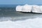 Ice on breakwaters in the sea, sea waves in the icy snow slush, sea coast in winter