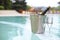 Ice bucket champagne bottle and two glasses near pool