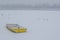 Ice capured yellow boat on frozen Danube river