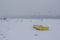 Ice capured yellow boat and people feeding birds on frozen Danube river