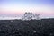 Ice chunk washed up on a black beach with lava sand during sunset hours