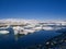 Ice chunks from the glacier drift in calm water