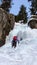 Ice climber free solo climbing an ice fall in the Swiss Alps