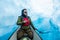 Ice climber paddling through narrow canyon cut through glacier ice, filled with deep blue water