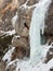 Ice Climber Rappelling Down Frozen Waterfall