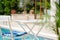 Ice coffee Cyprus Frappe Fredo against blue clear water of the swimming pool, on white table, with metal straw . Summer