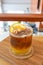 Ice coffee with orange juice on top slide orange on wooden table at cafe. vertical photo