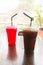 Ice coffee and red sweet juice in plastic cup.