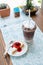 Ice coffee take away and cake on wooden background