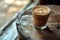 Ice coffee in a tall glass with cream poured over black table. Cold summer drink on a dark background