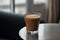 Ice coffee in a tall glass with cream poured over black table. Cold summer drink on a dark background