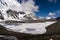 Ice-covered mountains lake with the clouds shadows