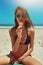 Ice cream, beach swimsuit and woman portrait on holiday by the sea and blue sky with happiness. Sun, sand and young