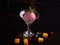 Ice cream with beets in a glass ice-cream bowl decorated with mint leaves on a dark background with slices of mango, blackberry, r
