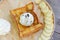 Ice cream on bread topped with honey side dishes whipped cream and banana on wooden dish