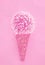 Ice cream cone made from confetti with flower onion on pink paper background. Trendy minimal pop art style and summer food concept