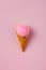 Ice cream cone with pink tennis ball on pastel pink background.