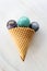 Ice-cream cone with round crystal stones on marble background as an refreshment concept or alternative medicine healing