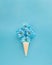 Ice cream cone with soft blue flowers like ice cream. Spring summer sunny days concept idea. Food aesthetic fashion