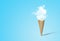 Ice cream cone with white cloud in blue background.