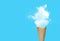 Ice cream cone with white cloud in blue background.