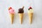 Ice cream cones, top view over white marble, strawberry, chocolate and vanilla