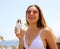 Ice cream girl eating on Tenerife beach in summer sun laughing happy. Young people lifestyle
