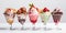 Ice cream in glass bowls with a variety of fruit and chocolate topping. Generative AI
