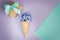 Ice cream horn or cone with purple hyacinth on a purple - mint background.
