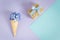 Ice cream horn or cone with purple hyacinth on a purple -mint background with gift boxes and bow.
